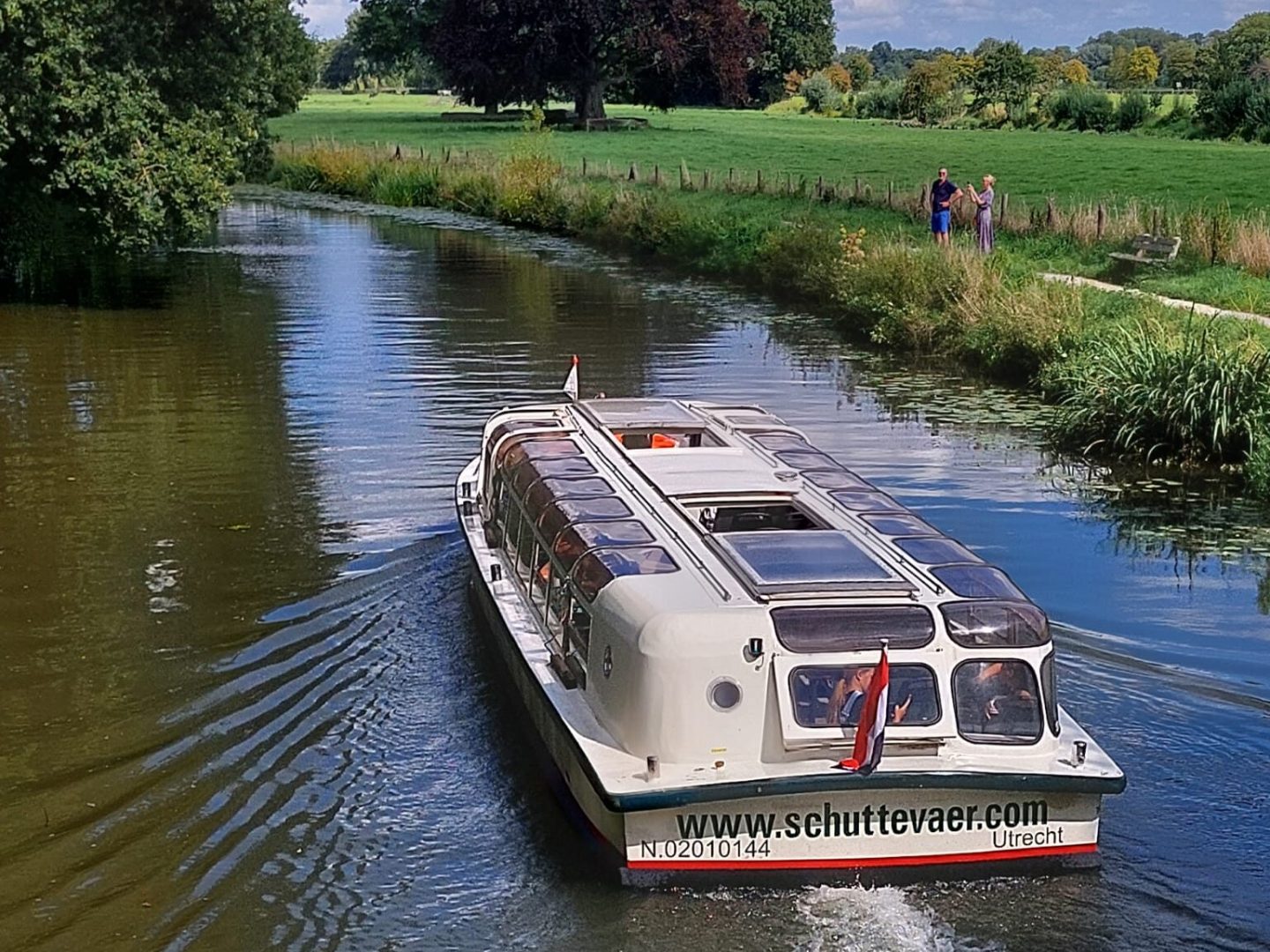 a boat traveling along a river next to a body of water