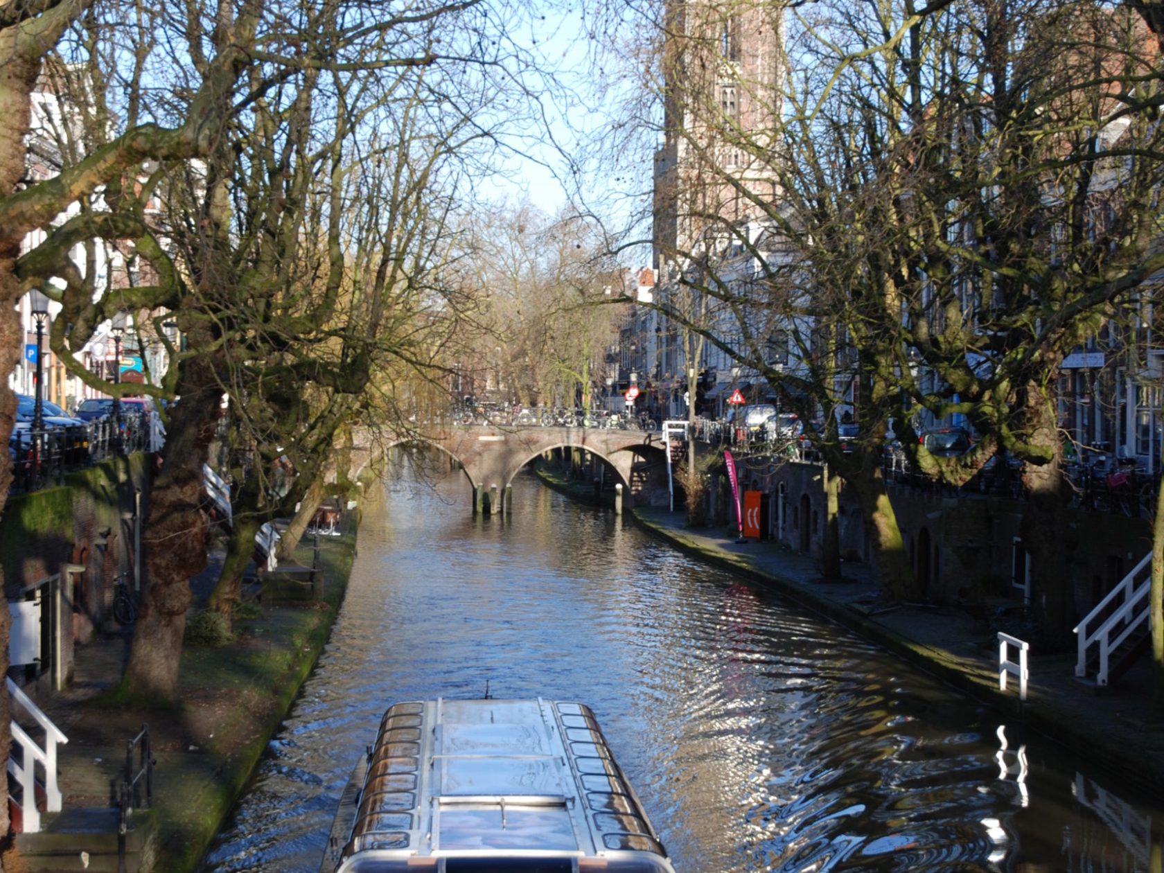 a boat floating along a river next to a body of water