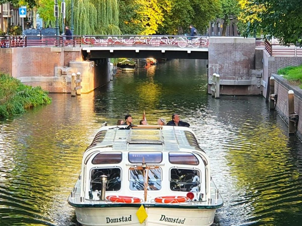 a boat floating along a river next to a body of water