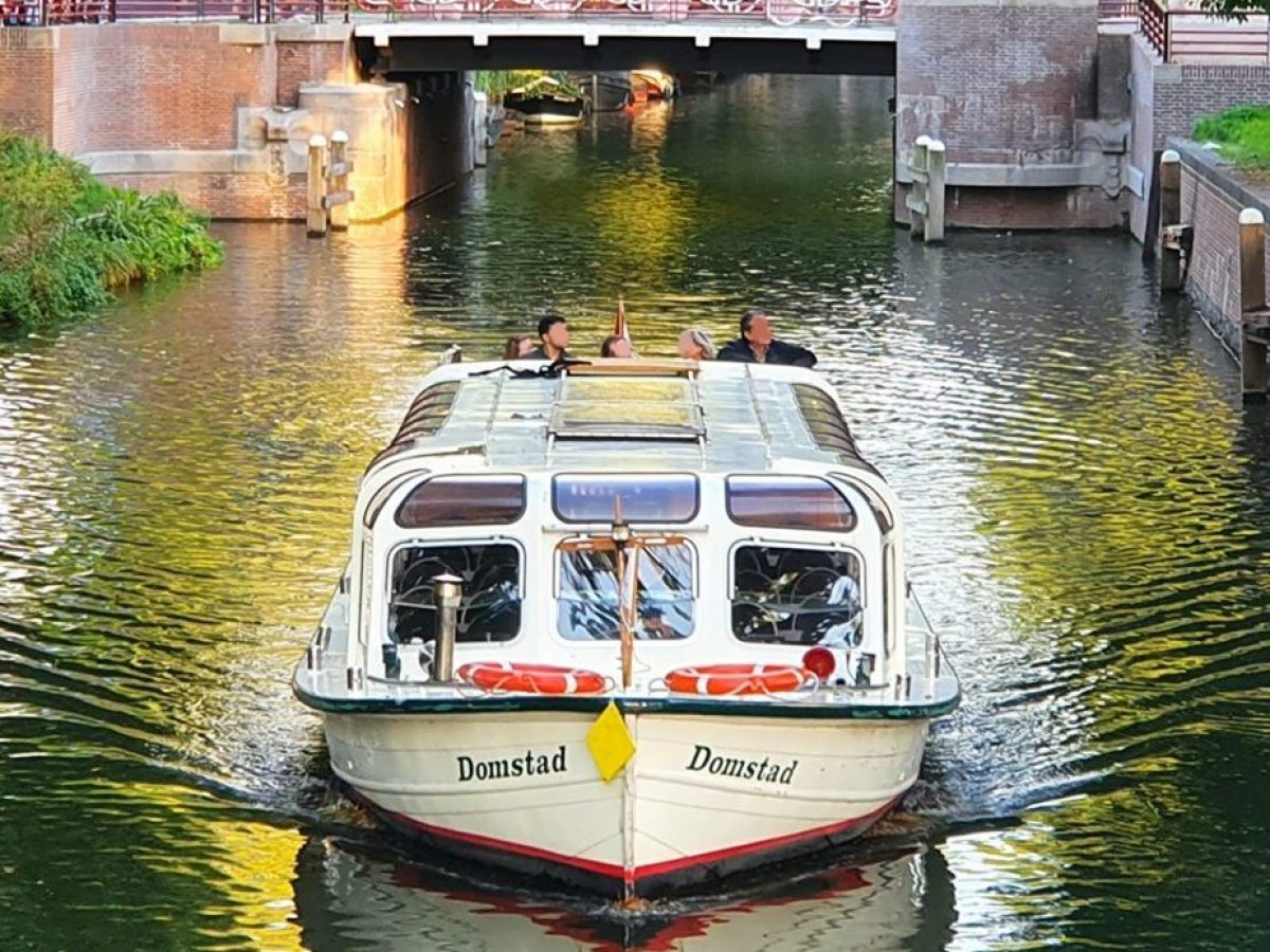 a boat floating along a river next to a body of water