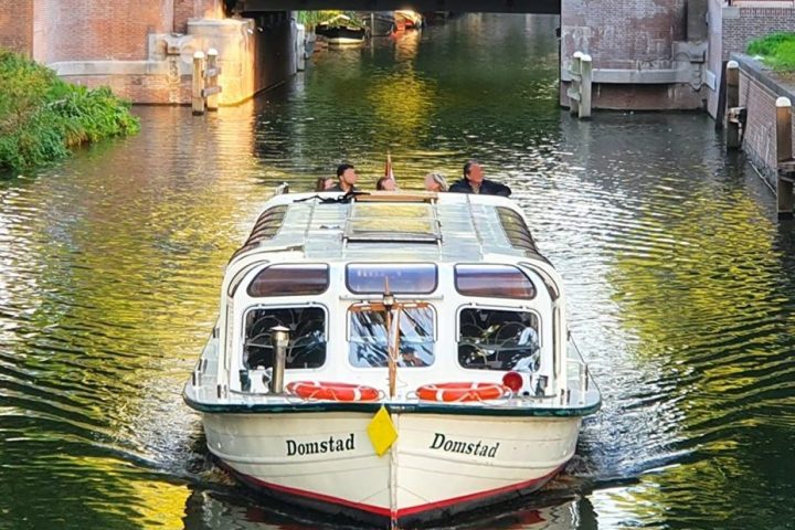 a boat floating along a river next to a body of water