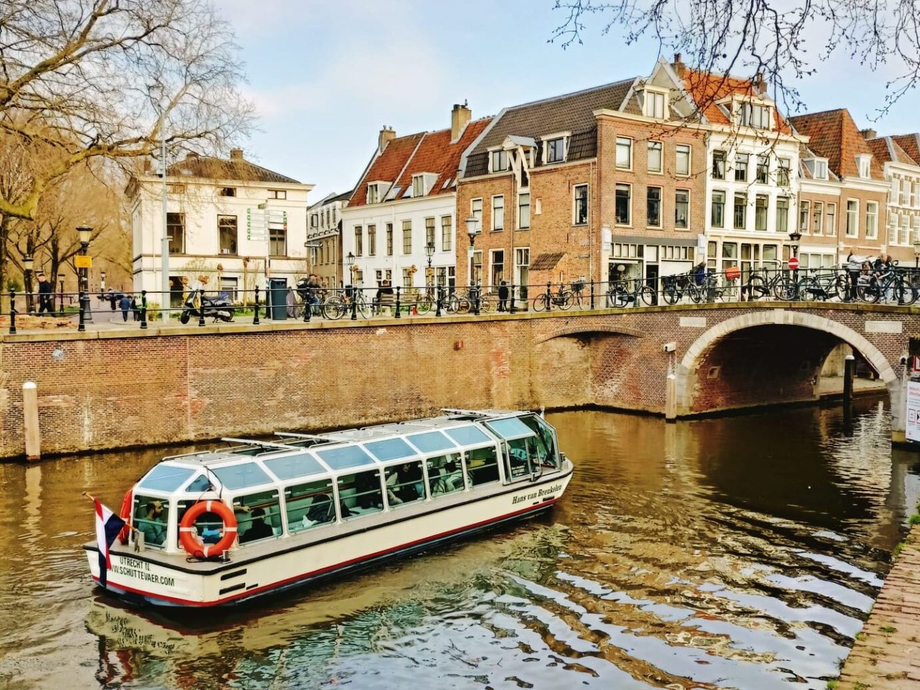 a boat floating along a river next to a body of water
