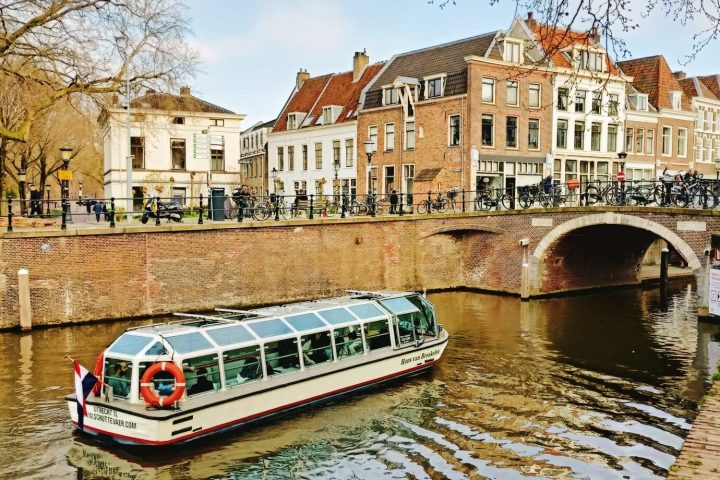 a boat floating along a river next to a body of water