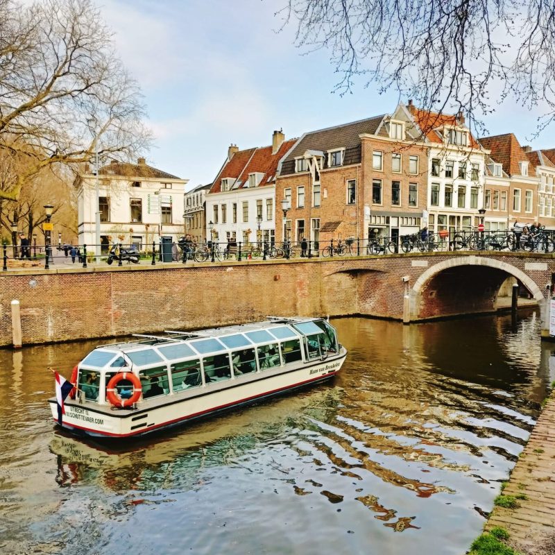 a boat floating along a river next to a body of water