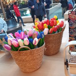 a group of people sitting at a table with a vase of flowers