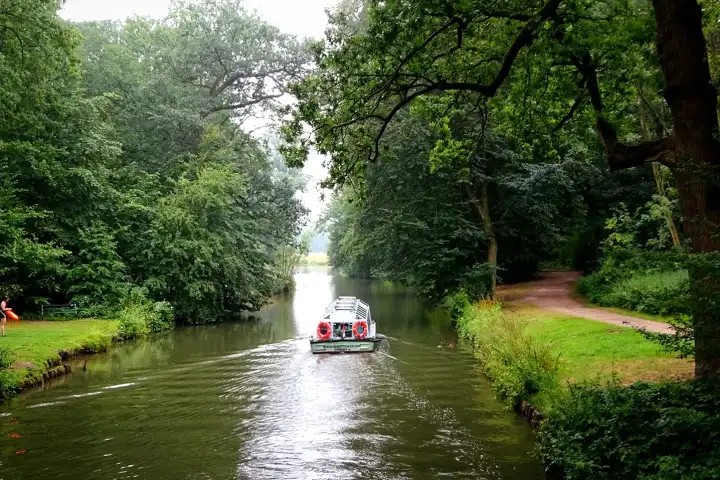 a small bus driving down a river