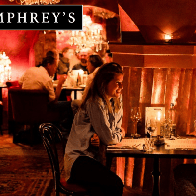 Two people dining at a cozy restaurant with warm lighting and red decor.